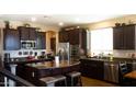 The kitchen features dark cabinets, stainless steel appliances, and a granite-topped island at 22812 N 123Rd Dr, Sun City West, AZ 85375