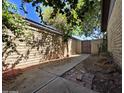 View of the backyard with block wall, walkway, desert landscaping, and a metal gate at 2515 S Maple Ave # 103, Tempe, AZ 85282