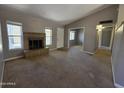 Carpeted living room features brick fireplace, picture window, and open view to the entry at 2515 S Maple Ave # 103, Tempe, AZ 85282