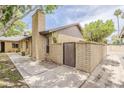 Brick home exterior showing a gated side entrance, chimney and partial view of the roofline at 2515 S Maple Ave # 103, Tempe, AZ 85282