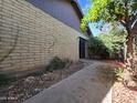 Side yard showing exterior brick wall, walkway, and mature foliage and fruit tree at 2515 S Maple Ave # 103, Tempe, AZ 85282