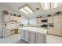 Bright eat-in kitchen with a center island, neutral cabinets, tile counters and flooring, and recessed lighting at 2629 E Verbena Dr, Phoenix, AZ 85048
