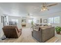 Spacious living room with plush carpeting, light walls, ceiling fans, fireplace, and ample natural light at 2629 E Verbena Dr, Phoenix, AZ 85048