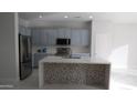 Modern kitchen features stainless steel appliances, stylish backsplash, and a spacious island with tiled accents at 29462 N 126Th Ln, Peoria, AZ 85383