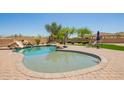 Sparkling pool featuring a rock slide, surrounded by a brick patio and lush landscaping at 32525 N 41St Way, Cave Creek, AZ 85331