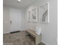 Inviting entryway with tiled floors, a bench, and artwork, creating a welcoming atmosphere for guests at 38082 W Santa Barbara Ave, Maricopa, AZ 85138