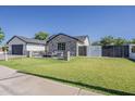 An inviting green lawn and stylish fence enhance the curb appeal of this charming home at 3834 E Clarendon Ave, Phoenix, AZ 85018