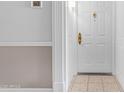 Close-up of white entry door with tiled floor and elegant decorative hardware at 4200 N Miller Rd # 112, Scottsdale, AZ 85251