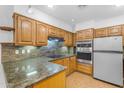 Well-lit kitchen with stainless steel appliances, wooden cabinets, and mosaic backsplash at 4200 N Miller Rd # 112, Scottsdale, AZ 85251