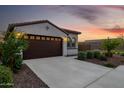Welcoming home exterior featuring a tile roof, spacious two-car garage, and carefully landscaped front yard at 4352 N 91St Gln, Phoenix, AZ 85037