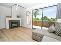 Bright living room with modern fireplace, wood floors, light-colored sofa, and sliding doors to the patio at 5122 E Shea Blvd # 1043, Scottsdale, AZ 85254