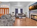 Bright living room showcasing a cozy fireplace, comfortable sofas, laminate wood floors and ample natural light at 5322 W Wethersfield Dr, Glendale, AZ 85304