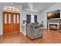 Bright living room showcasing a cozy fireplace, comfortable sofas, laminate wood floors and ample natural light at 5322 W Wethersfield Dr, Glendale, AZ 85304