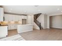 Bright open-concept kitchen with white cabinets, tile flooring, and staircase access at 5859 E Covey Ln, Phoenix, AZ 85054