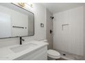 Modern bathroom with white vanity, dark fixtures, and a walk-in shower with gray tiling at 6601 N 46Th Ln, Glendale, AZ 85301
