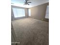 Comfortable bedroom with carpet, a ceiling fan, and multiple windows providing ample natural light at 6619 W Cordia Ln, Phoenix, AZ 85083