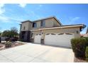 Inviting two-story home showcasing a spacious driveway and a three-car garage with stone accents at 6619 W Cordia Ln, Phoenix, AZ 85083