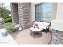 Cozy front patio with a charming wicker sofa and decorative round table, perfect for outdoor relaxation at 6619 W Cordia Ln, Phoenix, AZ 85083