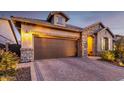 View of home featuring a brick driveway, a brown garage door, and stone veneer at 6929 E Quill St, Mesa, AZ 85207