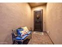 Cozy front porch with a bench, decorative pillows, and a secure front door at 6929 E Quill St, Mesa, AZ 85207