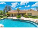 Close-up of a beautiful pool with a rock-lined edge, seamlessly connecting with the home's backyard patio at 7734 E Monica Dr, Scottsdale, AZ 85255