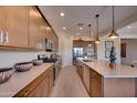 Spacious kitchen featuring stainless steel appliances, an island, and modern lighting fixtures at 7854 W Tether Trl, Peoria, AZ 85383