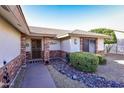 Inviting front porch with a decorative door, complemented by low-maintenance landscaping and brick accents at 7916 E Naranja Ave, Mesa, AZ 85209