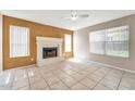 Bright living room featuring tile floors, a fireplace, and natural light from multiple windows at 8871 W Maryland Ave, Glendale, AZ 85305