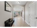 Hallway with light gray walls, tile flooring, decorative archway, and a dark wooden bench at 11129 E Reginald Ave, Mesa, AZ 85212