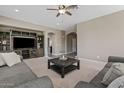 Cozy living room with a large entertainment center, gray sofas, and modern ceiling fan at 11129 E Reginald Ave, Mesa, AZ 85212