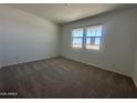 Spacious bedroom featuring neutral carpet and window providing ample natural light at 11796 N Vanero Ct, Maricopa, AZ 85139