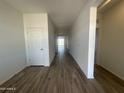 Bright hallway with wood-look tile flooring leading to rooms filled with natural light at 11796 N Vanero Ct, Maricopa, AZ 85139