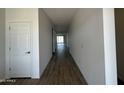 Bright hallway with wood-look tile flooring leading to a living area at 11796 N Vanero Ct, Maricopa, AZ 85139