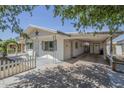 Side view of home showing a covered parking area, white picket fence, and a decorative archway at 120 S Olive --, Mesa, AZ 85204