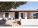 Inviting front entrance with a stylish black door and colorful flowering plants at 12271 N 74Th St, Scottsdale, AZ 85260