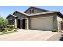 Attractive single-story home featuring stone accents and a brick driveway at 1228 W Snowbell Ave, Queen Creek, AZ 85140