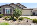 Lovely single-story home with a well-maintained front yard showcasing desert rock and plants at 1228 W Snowbell Ave, Queen Creek, AZ 85140