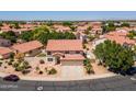 Aerial view of a home with a tile roof in a residential neighborhood, with mature landscaping at 12748 N 57Th Dr, Glendale, AZ 85304