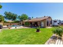 Lush backyard with a sparkling pool, a covered patio, and ample green space perfect for outdoor living and entertaining at 15256 N 62Nd Ave, Glendale, AZ 85306