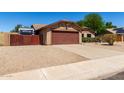 Inviting single-story home with desert landscaping, a wide driveway, and a two-car garage at 15256 N 62Nd Ave, Glendale, AZ 85306