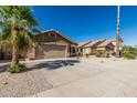 Attractive single-level home featuring a well-maintained yard, lush palm tree, and a two-car garage at 16242 W Maui Ln, Surprise, AZ 85379