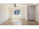 Open living space with ceramic tile flooring, ceiling fan, and arched window at 17244 N 36Th Ln, Glendale, AZ 85308