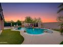 Backyard oasis featuring a pristine pool with rock features and lush landscaping, perfect for relaxation at 1753 N Berrett --, Mesa, AZ 85207