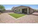 The backyard is gravel-covered with a grass area and patio at 17864 W Fetlock Trl, Surprise, AZ 85387