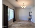 Inviting living room with neutral paint, chandelier, and stylish wood-look flooring at 22121 N Greenland Park Dr, Maricopa, AZ 85139