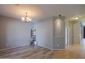 Bright and airy living room with wood-look flooring and modern chandelier at 22121 N Greenland Park Dr, Maricopa, AZ 85139