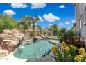 Beautiful backyard pool with waterfall feature, surrounded by lush landscaping and lounge chairs at 2741 S Gordon --, Mesa, AZ 85209
