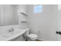 Clean, simple powder room with pedestal sink, toilet, floating shelves and a window at 31653 N 24Th Dr, Phoenix, AZ 85085