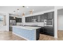 Beautiful kitchen with stainless steel appliances, white quartz counters and island with blue decorative accents at 31653 N 24Th Dr, Phoenix, AZ 85085