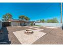 Private backyard with a cozy fire pit and low-maintenance desert landscaping at 3231 W Banff Ln, Phoenix, AZ 85053